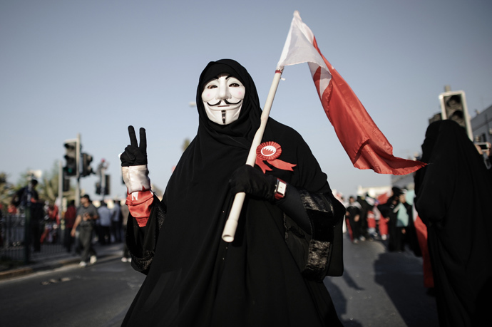 A Bahraini woman wearing a Guy Fawkes mask used by the Anonymous movement flashes the 'V-sign' for victory during an anti-government protest in the village of Jannusan, west of the capital Manama, on September 27, 2013 (AFP Photo / Mohammed Al-Shaikh) 