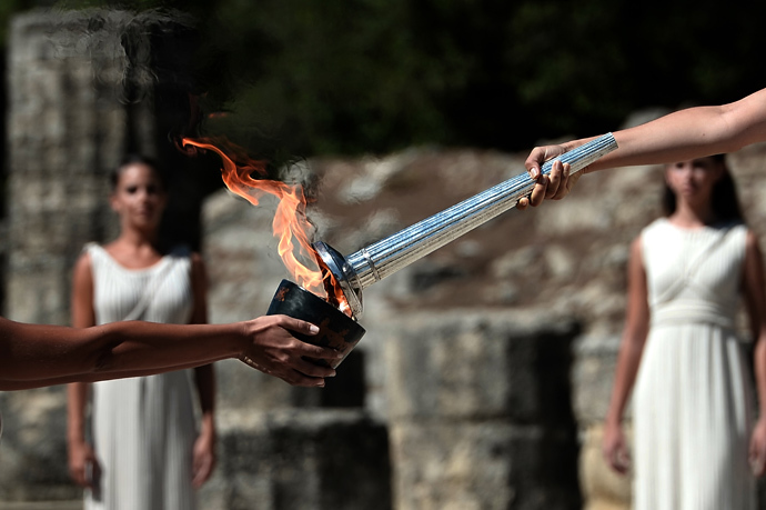 Greek actress Ino Menegaki (R) acting as the high priestess holds the Olympic Flame at the Temple of Hera on September 29, 2013 during the lighting ceremony in ancient Olympia (AFP Photo / Aris Messinis) 