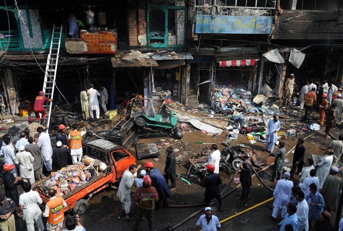 Pakistani security officials and volunteers gather at the site of a bomb explosion in the busy Kissa Khwani market in Peshawar on September 29, 2013 (AFP Photo / A. Majeed) 