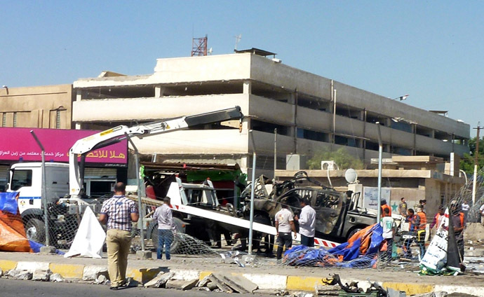 A destroyed vehicle is removed following a car bomb in a car park in Baghdad Jadida, on September 30, 2013. (AFP Photo)