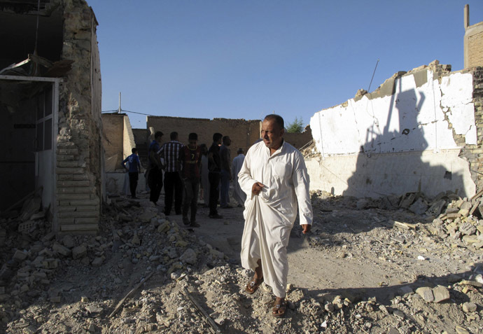 A man walks near a damaged Shi'ite mosque a day after a suicide bomb attack in Hilla, 60 km (40 miles) south of Baghdad, September 30, 2013. (Reuters/Habib)