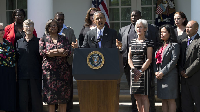 US President Barack Obama speaks alongside Secretary of Health and Human Services Kathleen Sebelius (R) and people who will benefit from health insurance plans under the Affordable Care Act, as well speaks about the government shutdown in the Rose Garden of the White House in Washington, DC, October 1, 2013. (AFP Photo/Saul Loeb)