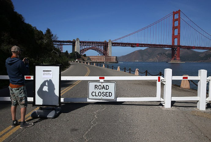 A visitor takes a picture of a sign announcing the closure of the Fort Point National Historic Site due to the partial government shutdown on October 1, 2013 in San Francisco, California. (AFP Photo / Justin Sullivan)