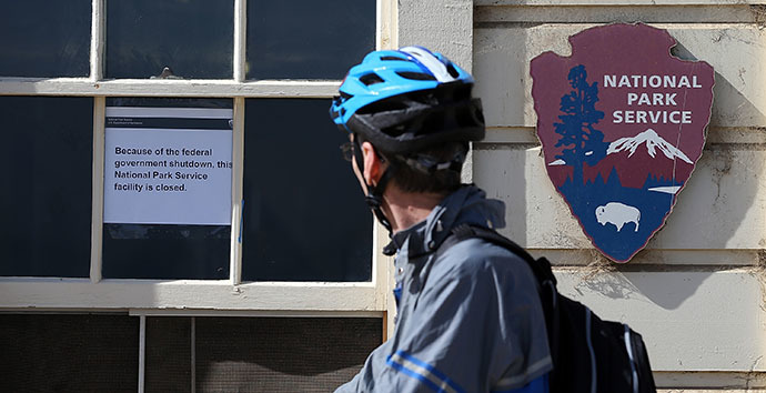 A cyclist reads a sign announcing the closure of a Park Service facility at Crissy Field due to the partial government shutdown on October 1, 2013 in San Francisco, California. (AFP Photo / Justin Sullivan)