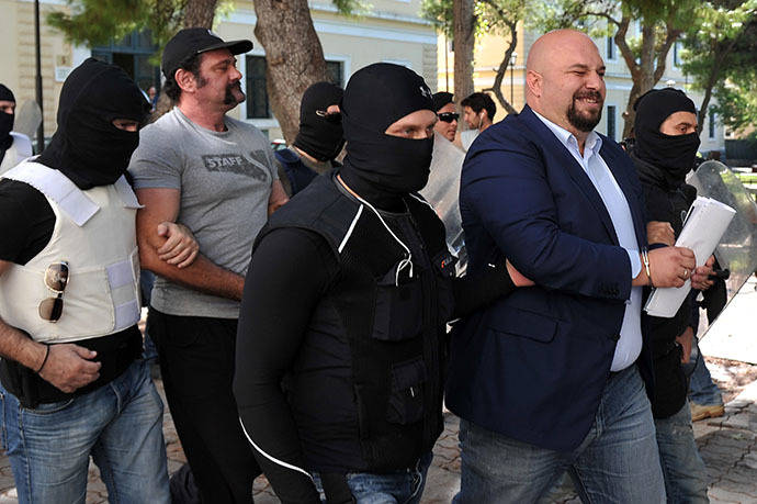 Policemen bring Golden Dawn lawmakers Ilias Panagiotaros (2nd R) and Giannis Lagos (2nd L) to the court in Athens on October 1, 2013. (AFP Photo / Louisa Gouliamaki)