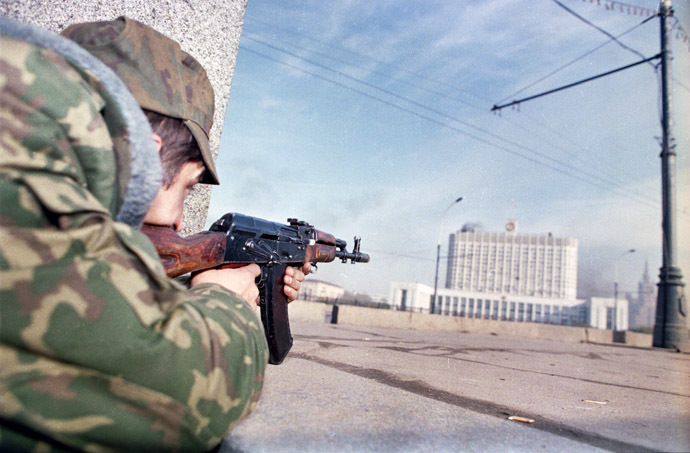 A picture taken on October 4, 1993, shows a pro-Yeltsin forces officer firing his Kalashnikov assault rifle at the Russian parliament building, also known as the White House, during the parliamentary revolt in Moscow. (AFP Photo/Alexander Nemenov)