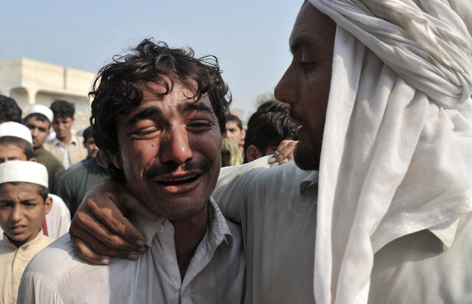 An Afghan man weeps over the death of his brother, allegedly killed in a NATO air strike, on the outskirts of Jalalabad in Nangarhar province on October 5, 2013. (AFP Photo / Noorullah Shirzada)