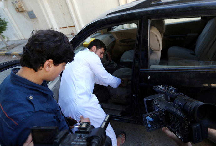 Abdullah al-Raghie (CL) and Abdul Moheman al-Raghie (L), the sons of al-Qaeda suspect Abu Anas al-Libi, show members of the press their father's car from which he was taken by US special forces in a commando raid in Nofliene, five kilometres from the Libyan capital Tripoli on October 6, 2013, sealing a 15-year manhunt for him. (AFP Photo)