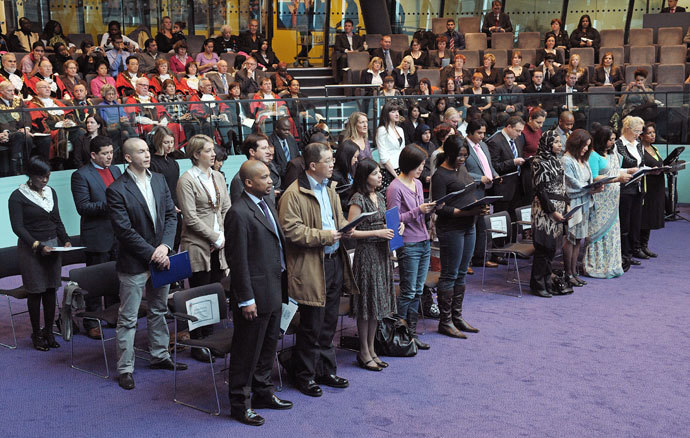 Immigrants to the United Kingdom take an oath before being presented with a certificate of citizenship by the London Mayor Boris Johnson, during a 'Citizenship Ceremony' at City Hall, London.(AFP Photo / Carl de Souza)