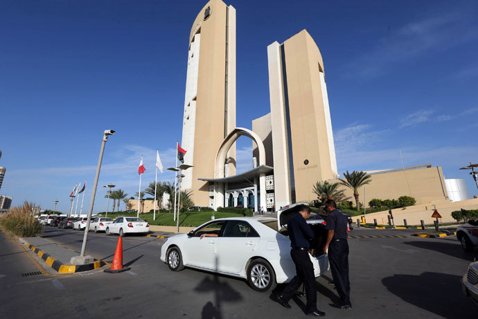A general view taken on October 10, 2013 shows security checking a vehicle outside the Corinthia hotel (background) in the Libyan capital Tripoli after Libyan Prime Minister Ali Zeidan was kidnapped from the hotel, where he resides. (AFP Photo / Mahmud Turkia)