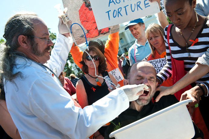 Protester Andres Thomas (R bottom) is force-fed by Dr. Terry Fitzgerald (L) during a demonstration in solidarity with hunger-striking inmates at the US prison at Guantanamo Bay, in front of the White House in Washington on September 6, 2013. (AFP Photo / Nicholas Kamm)