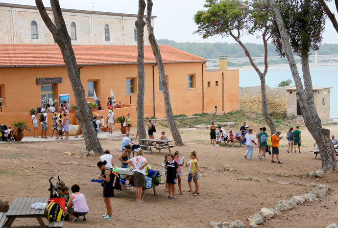 Tourists rest outside a hotel managed by the San Giacomo cooperative, on the Italian island of Pianosa on August 7, 2012.(AFP Photo / Fabio Muzzi)