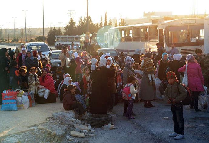 A handout picture released by the official Syrian Arab News Agency (SANA) on October 12, 2013 shows Syrian women and children waiting before being evacuated by Syria's Red Crescent from a Damascus suburb that has been under siege by the Syrian army for months. (AFP Photo)