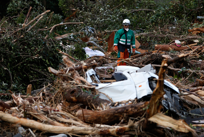 A rescue worker looks for a victim of a landslide caused by Typhoon Wipha in Izu Oshima island, south of Tokyo October 17, 2013 (Reuters / Yuya Shino)
