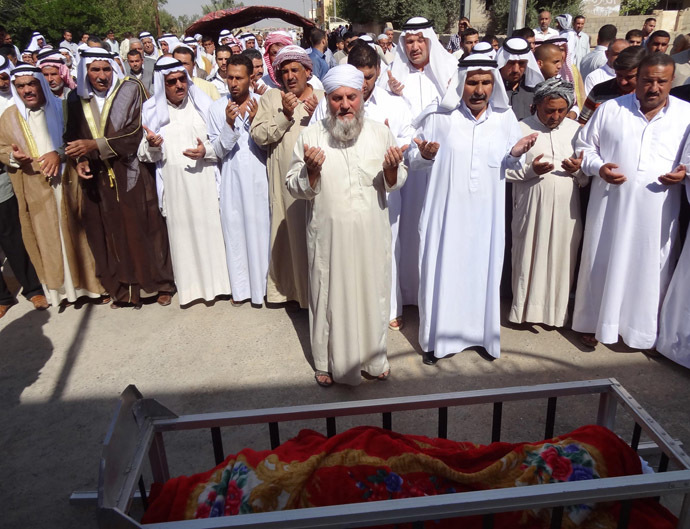 Iraqis pray during a funeral on October 17, 2013 over the body of one of the victims of a car bomb attack which targeted worshippers in a Sunni mosque following prayers marking the start of the Eid al-Adha Muslim holiday two days ago, in the northern Iraqi city of Kirkuk. (AFP Photo/Marwan Ibrahim)