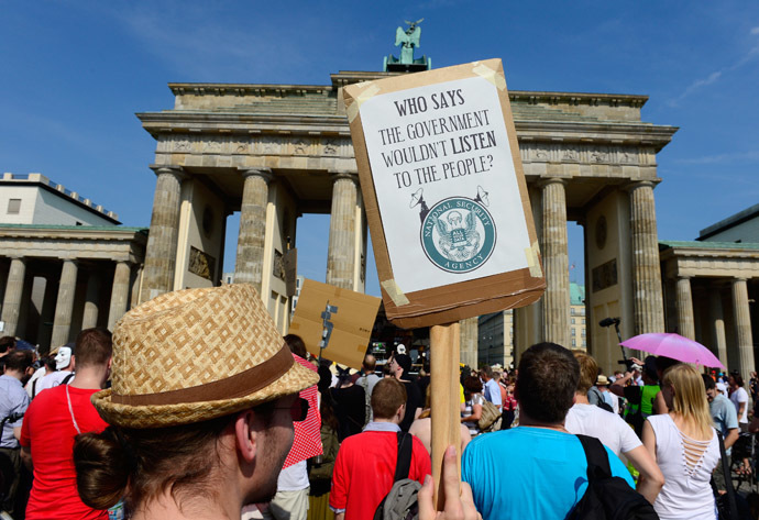 Demonstrators hold up banners as they take part in a protest in front of Berlin's landmark Brandenburg Gate against the US National Security Agency (NSA) collecting German emails, online chats and phone calls and sharing some of it with the country's intelligence services in Berlin on July 27, 2013 (AFP Photo/John Macdougall)