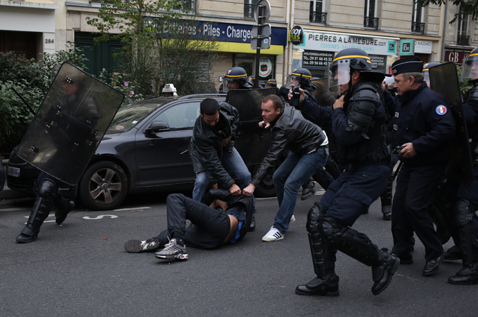 Anti riot police officers arrest a man as high school students demonste in Paris, on October 18, 2013, in protest against the deportation of foreign pupils following the high-profile eviction of a 15-year-old Roma girl (AFP Photo / Kenzo Tribouillard) 