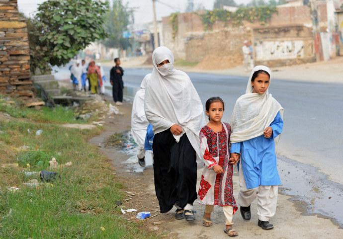 Pakistani schoolgirls walk along a path after school in Mingora, a town in Swat valley (AFP Photo / A Majeed) 