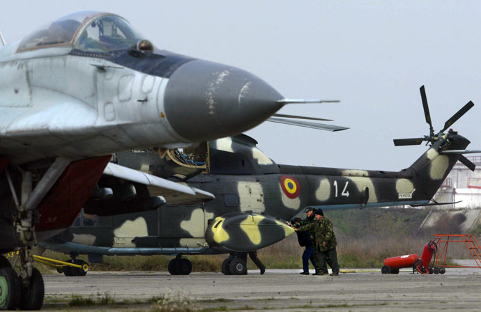 Members of the military maintenance personnel push a helicopter at the Aerian Military Base nr. 86, near the village of Mihail Kogalniceanu, some 250kms East of Bucharest (AFP Photo)