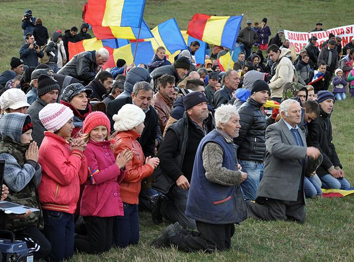 Protesters knee to pray during an anti shale gas exploration protest in Silistea village, on October 19, 2013. (AFP Photo / Adrian Arnautu)