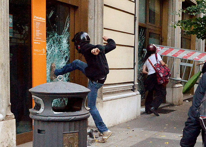 People try to broke the windows of an Unicredit bank agency during an anti-austerity protest on October 19, 2013 in Rome. (AFP Photo / Alberto Pizzoli)