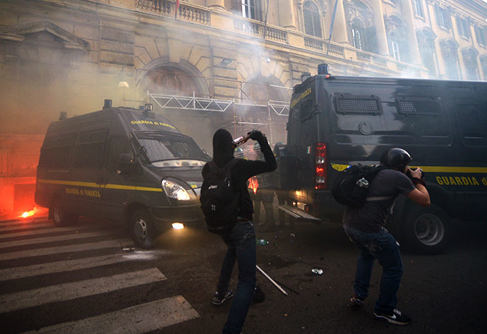 A man throws a bottle in direction of policem during clashes on the sidelines of an anti-austerity protest on October 19, 2013 in Rome. (AFP Photo / Filippo Monteforte)