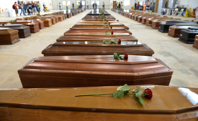 Coffin of victims are seen in an hangar of Lampedusa airport on October 5, 2013 after a boat with migrants sank killing more than hundred people. (AFP Photo / Alberto Pizzoli)