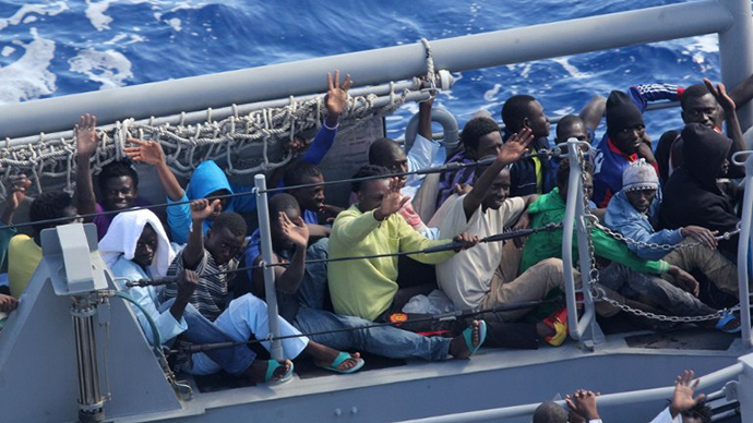 Distressed persons wave after being transferred Thursday, October 17, 2013 from the amphibious transport dock ship USS San Antonio (LPD 17) to Armed Forces of Malta offshore patrol vessel P52 on the Mediterranean Sea. (AFP Photo / US Navy)