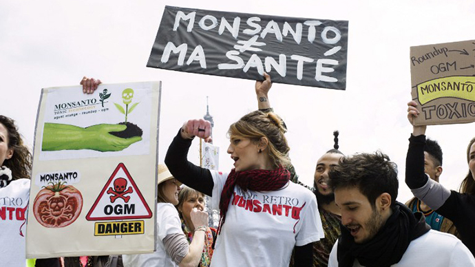 People hold signs during one of many worldwide "March Against Monsanto" protests against GMOs and agro-chemicals (AFP Photo / Fred Dufour)
