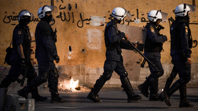 Bahraini riot policemen try to chase anti-regime protesters during clashes following the funeral of Ali Khalil Sabbagh in the village of Bani Jamrah, west of Manama, on October 23, 2013. (AFP Photo / Mohammed al-Shaikh)