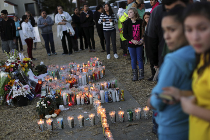 People look over a makeshift memorial for Andy Lopez Cruz at the site of his death in Santa Rosa, California October 24, 2013. (Reuters/Robert Galbraith)