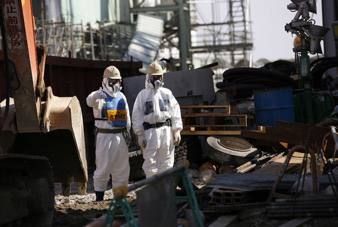 Workers wearing protective suits and masks are seen next to the No.4 reactor at Tokyo Electric Power Company's (TEPCO) tsunami-crippled Fukushima Daiichi nuclear power plant in Fukushima prefecture (Reuters/Issei Kato)