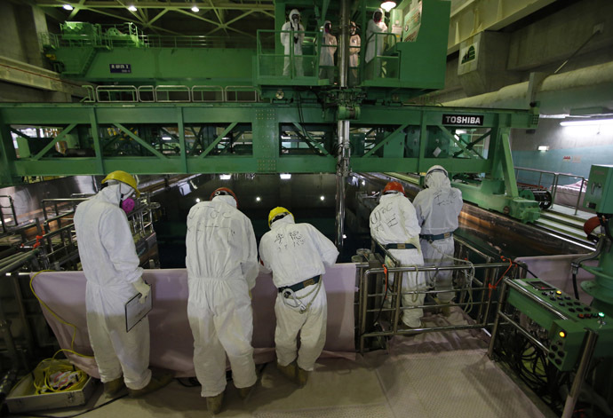 Workers wearing protective suits and masks are seen next to the spent fuel pool inside the Common Pool Building, where all the nuclear fuel rods will be stored for decommissioning, at the Tokyo Electric Power Co (TEPCO) tsunami-crippled Fukushima Daiichi nuclear power plant in the town of Okuma, Fukushima prefecture (AFP Photo/Issei Kato)