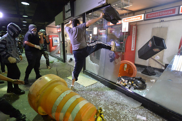 Masked demonstrators vandalize bank ATM machines following a demonstration against rising public transport costs and demanding better public services in Sao Paulo, Brazil, on October 25, 2013. (AFP Photo/Nelson Almeida)