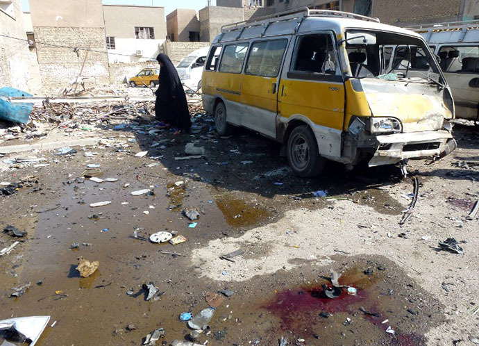 An Iraqi woman walks across the debris following an explosion at a bus center on October 27, 2013, in the the Mashtal district of the capital Baghdad (AFP Photo / Sabah Arar)