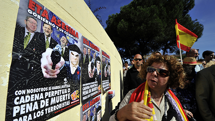 A woman looks at posters against ETA and the Spanish government during a gathering with thousands of Spaniards at Plaza de Colon on October 27, 2013. (AFP Photo / Gerard Julien)