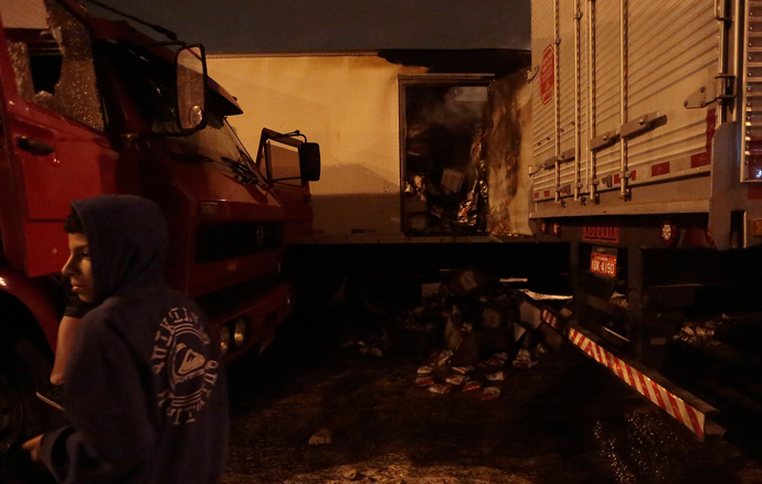 Riot sence of burnt trucks at highway in Sao Paulo, on October 28, 2013, following disturbances triggered by the accidental fatal shooting --on the eve-- of a 17-year-old boy by the police (AFP Photo / Miguel Schincariol)