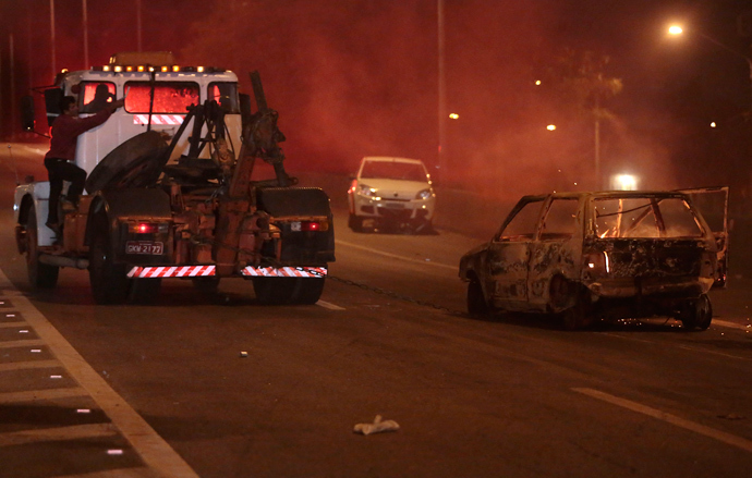 View of a car on fire in a highway in Sao Paulo, on October 28, 2013, following disturbances triggered by the accidental fatal shooting --on the eve-- of a 17-year-old boy by the police (AFP Photo / Miguel Schincariol)