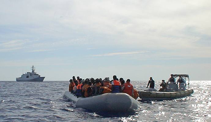 In this handout picture released by the Italian navy on October 31, 2013 migrants sit in a boat during a rescue operation off the coast of Sicily on October 30, 2013. (AFP Photo / Marina Militare)
