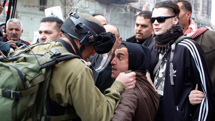 An Israeli soldier argues with a Palestinian protester during clashes in the West Bank city of Hebron March 1, 2013.(Reuters / Mussa Qawasma)