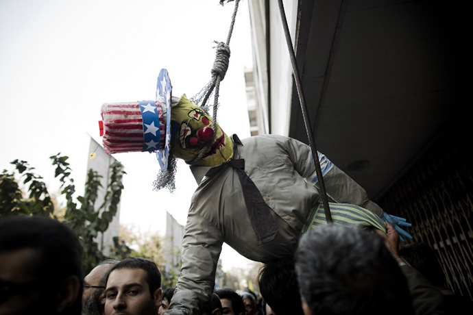An Iranian man holds an effigy of Uncle Sam with a rope around his neck outside the former US embassy in Tehran on November 4, 2013, during a demonstration to mark the 34th anniversary of the 1979 US embassy takeover. (AFP Photo / Behrouz Mehri)