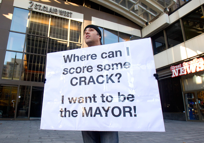 Nic Bibassis from Toronto holds a sign as Toronto Mayor Rob Ford (not seen) attends his weekly radio show at News Talk 1010 in Toronto (Reuters / Fred Thornhill) 