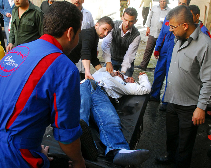 A handout picture released by the official Syrian Arab News Agency (SANA) on November 6, 2013, shows Syrians carrying an injured man after a bomb explosion allegedly rocked the heart of the Syrian capital Damascus. (AFP Photo)