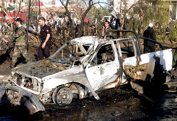 People gather around wreckage after a car bomb in Suweida city, November 6, 2013, in this handout picture released by Syria's national news agency SANA. (Reuters)