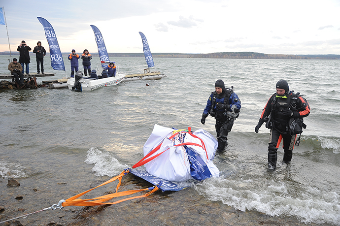 Divers pull a meteor fragment from Lake Chebarkul. (Aleksandr Kondratuk / RIA Novosti)