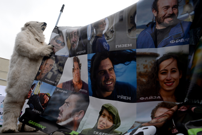 Wearing costume of a polar bear a Greenpeace activist holds a poster with pictures of the "Arctic 30" detained Greenpeace activists during a rally in their support (AFP Photo)