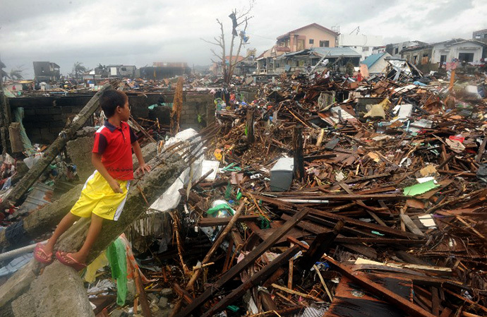 A boy looks at the debris of destroyed houses in Tacloban, on the eastern island of Leyte on November 12, 2013, after Super Typhoon Haiyan, the most powerful storm in the world this year, hit the Philippines on November 8. (AFP Photo / Noel Celis)