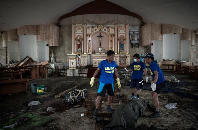 Dead bodies are taken away from a church to a morgue in Tacloban, on the eastern island of Leyte on November 12, 2013 after Super Typhoon Haiyan swept over the Philippines. (AFP Photo / Philippe Lopez)