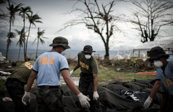 Dead bodies are unloaded at a makeshift morgue in Tacloban, on the eastern island of Leyte on November 12, 2013 after Super Typhoon Haiyan swept over the Philippines. (AFP Photo / Philippe Lopez)