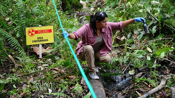 A woman shows crude oil from the Aguarico 4 well near Aguarico, Sucumbios province, Amazonian Peru, on September 17, 2013. (AFP Photo / Rodrigo Buendia)
